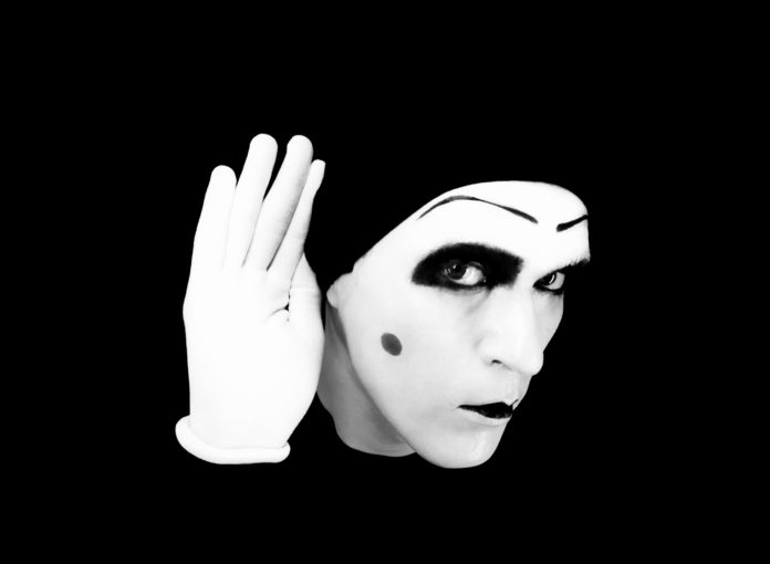 Portrait of overhearing mime in white gloves Eyes listening