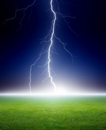 17691125 - big bright lightning, grenn grass field, dark blue night sky